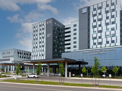 Modern hospital building with glass façade and signage for the learning centre